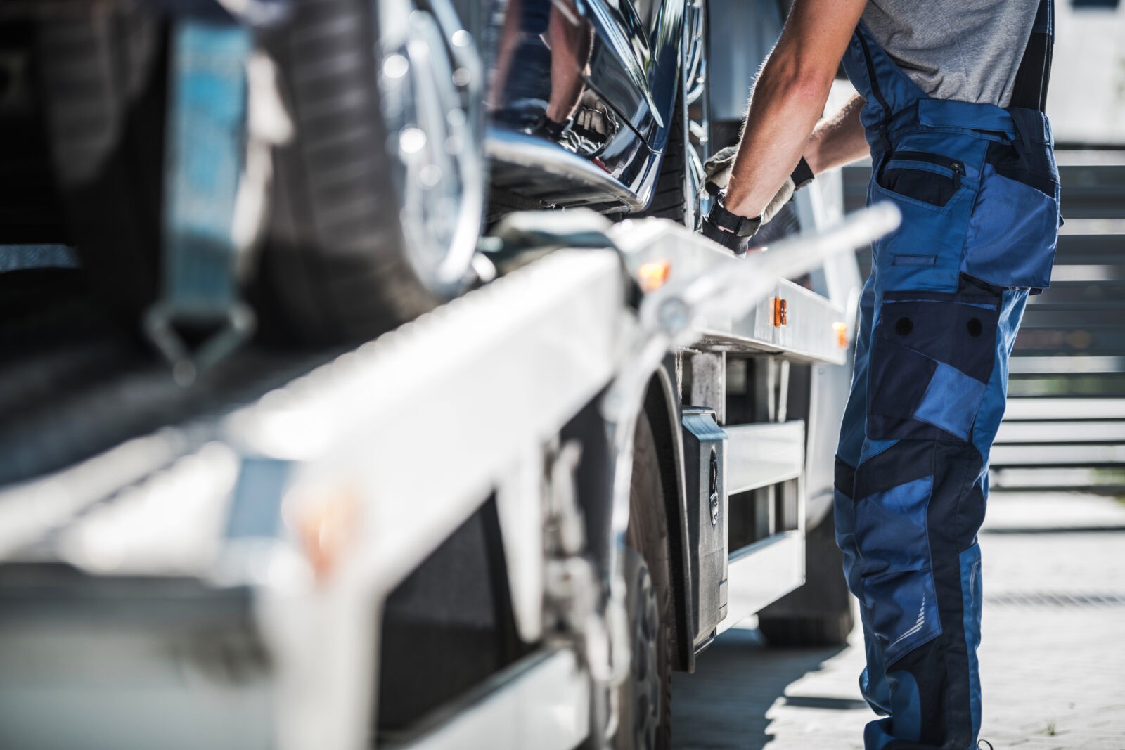 Professional Repo Worker Securing Car on a Towing Truck.